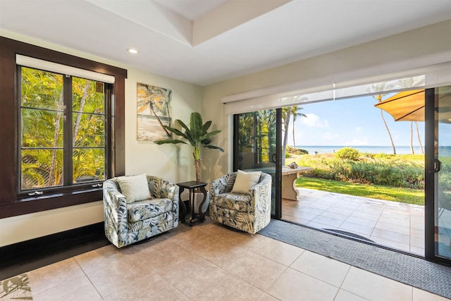 sitting room with light tile patterned flooring and a water view