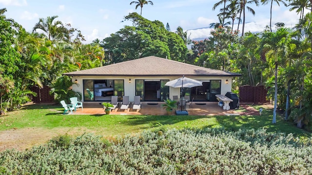 back of property featuring a lawn and a patio area