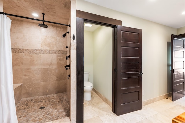 bathroom with curtained shower, tile patterned floors, and toilet