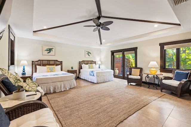 tiled bedroom with a raised ceiling, ceiling fan, and multiple windows