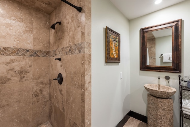 bathroom featuring a tile shower and sink