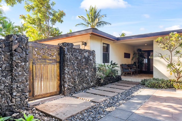 view of exterior entry with a patio area