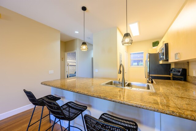 kitchen with pendant lighting, a breakfast bar, dark hardwood / wood-style floors, and black range with electric cooktop