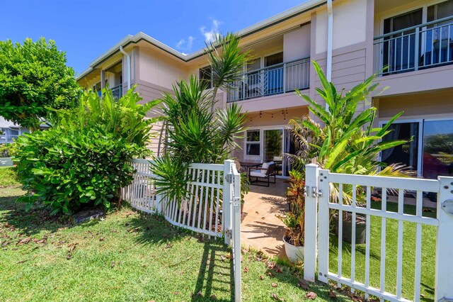 exterior space featuring a patio, a balcony, and a front yard