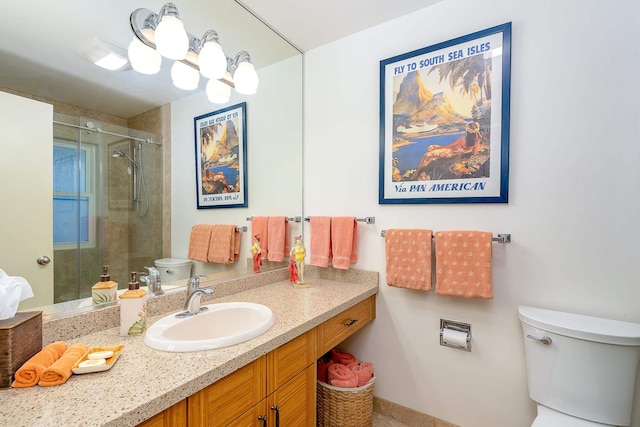 bathroom featuring vanity, a shower with shower door, and toilet