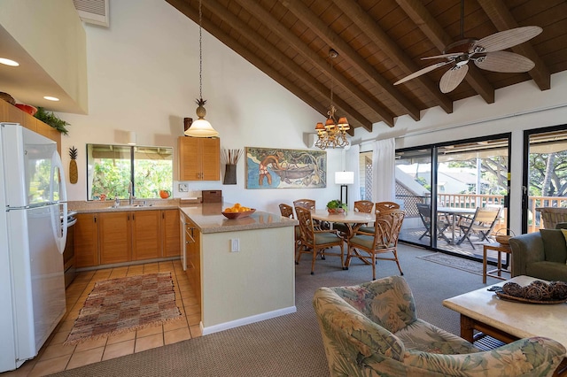 kitchen featuring white fridge, a kitchen island, beam ceiling, sink, and decorative light fixtures