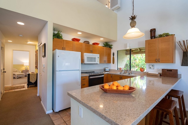 kitchen featuring white appliances, kitchen peninsula, light tile patterned floors, sink, and decorative light fixtures