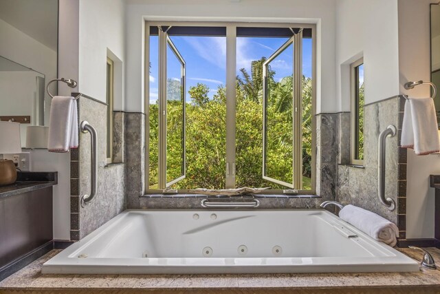 bathroom featuring plenty of natural light and a relaxing tiled tub