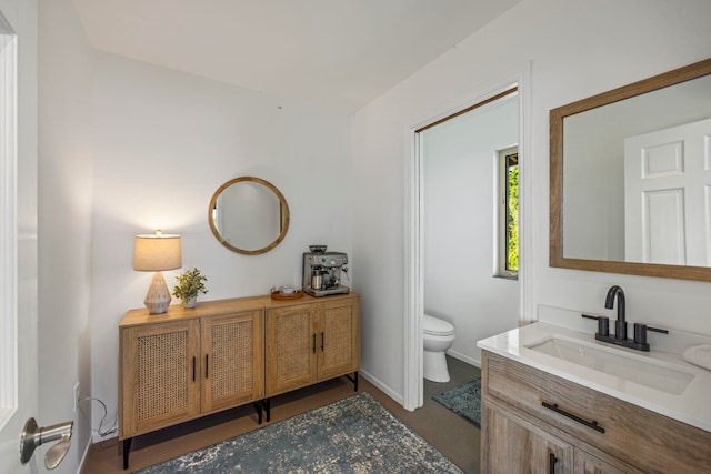 bathroom with vanity, toilet, and hardwood / wood-style flooring