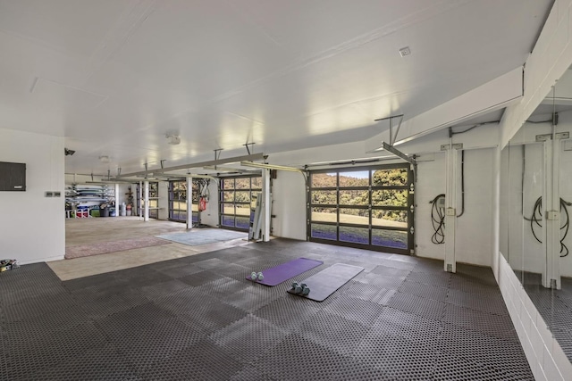 workout area featuring electric panel and a garage