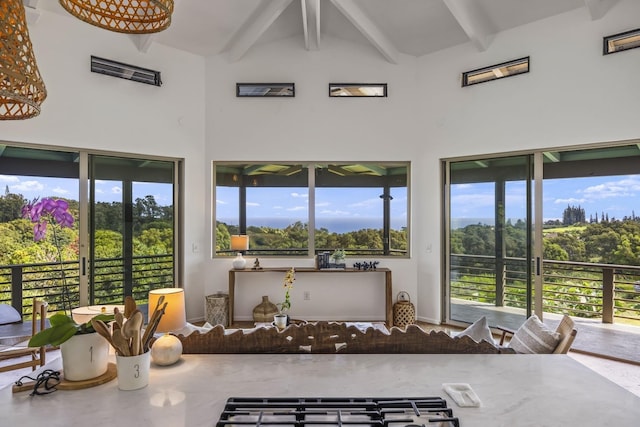 sunroom / solarium featuring vaulted ceiling with beams