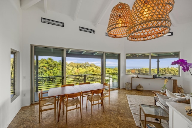 dining space with beam ceiling, a high ceiling, and baseboards