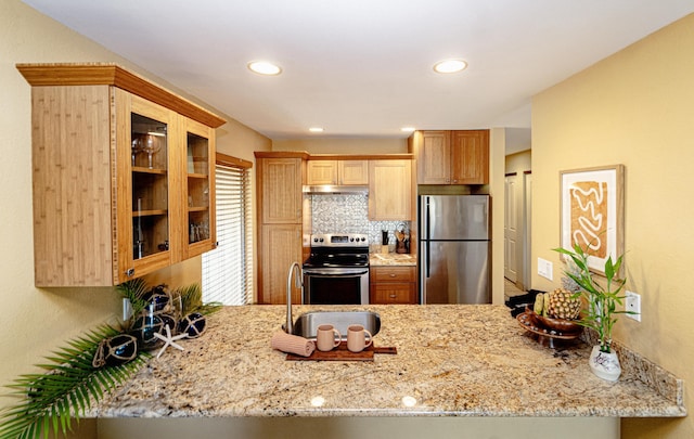 kitchen with stainless steel appliances, light stone countertops, and kitchen peninsula