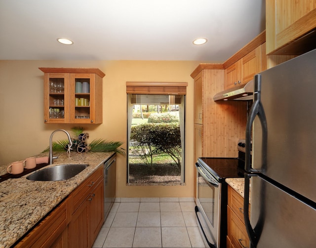 kitchen featuring sink, light tile patterned flooring, light stone countertops, and appliances with stainless steel finishes