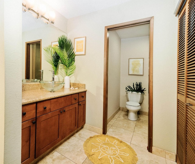 bathroom featuring tile patterned floors, vanity, and toilet