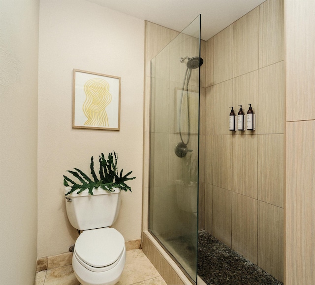 bathroom featuring tiled shower, tile patterned floors, and toilet