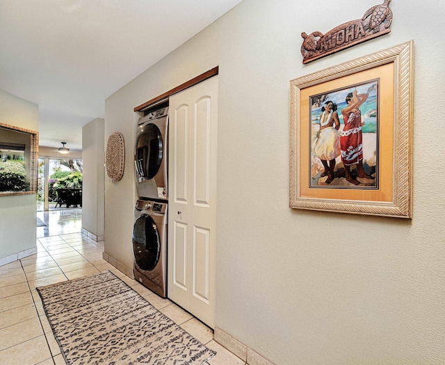 clothes washing area with stacked washer / dryer and light tile patterned floors