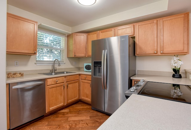 kitchen with light brown cabinetry, stainless steel appliances, sink, and light wood-type flooring