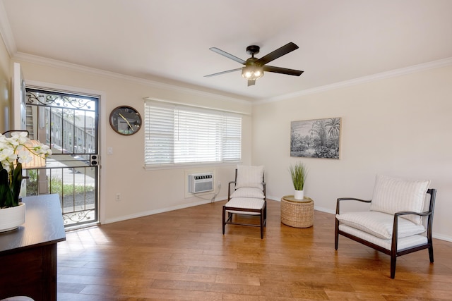 sitting room with crown molding, light hardwood / wood-style floors, a wall unit AC, and a healthy amount of sunlight