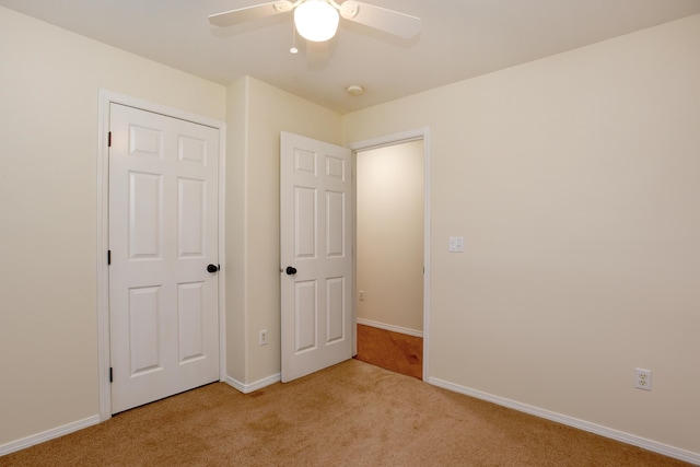 unfurnished bedroom featuring a closet, ceiling fan, and light carpet