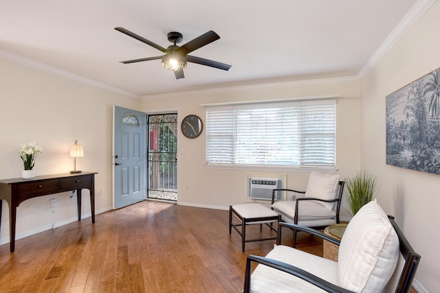 living area with crown molding, a wall unit AC, and hardwood / wood-style floors