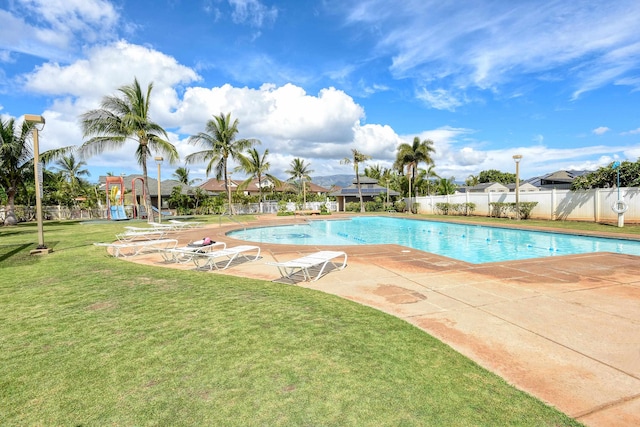 view of swimming pool featuring a patio area, a lawn, and a playground