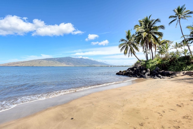 view of water feature with a mountain view and a view of the beach