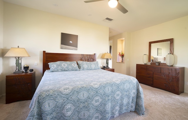 bedroom featuring a ceiling fan, visible vents, and light carpet