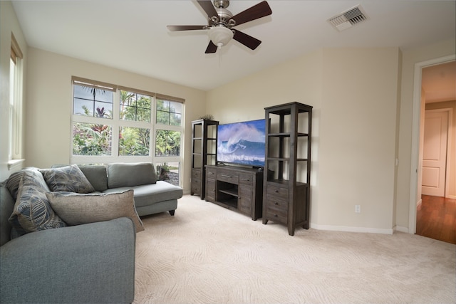 living area with light carpet, baseboards, visible vents, and ceiling fan