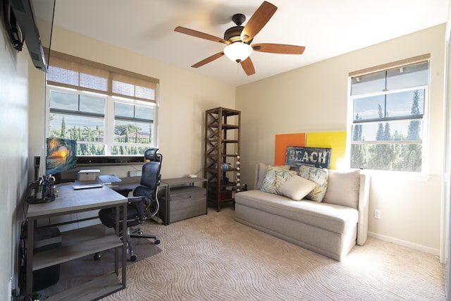 office area with baseboards, a ceiling fan, and light colored carpet