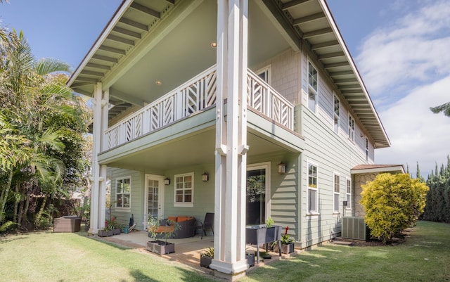 back of property featuring central AC, a lawn, and a balcony