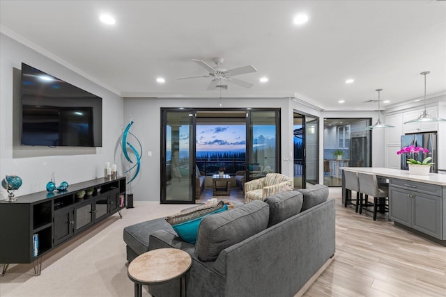 living room with crown molding, ceiling fan, and light hardwood / wood-style floors