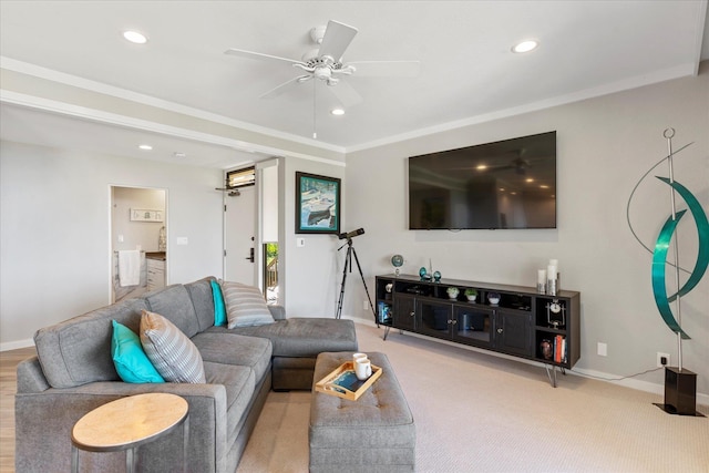 living room with ceiling fan, crown molding, and light colored carpet