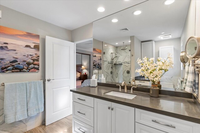 bathroom featuring hardwood / wood-style floors, vanity, and an enclosed shower