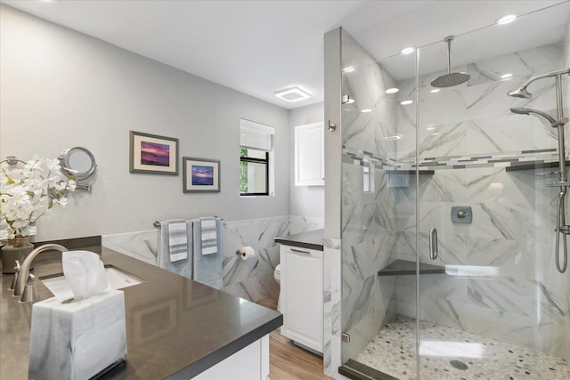 bathroom featuring vanity, toilet, walk in shower, tile walls, and wood-type flooring