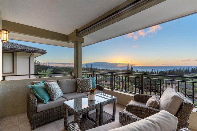 balcony at dusk featuring outdoor lounge area and a water view