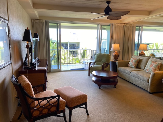 living room featuring beam ceiling, carpet flooring, and ceiling fan