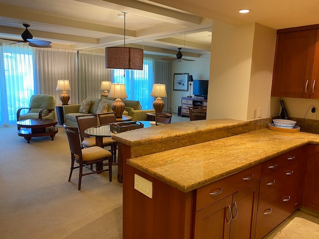 kitchen with light carpet, kitchen peninsula, beamed ceiling, and pendant lighting