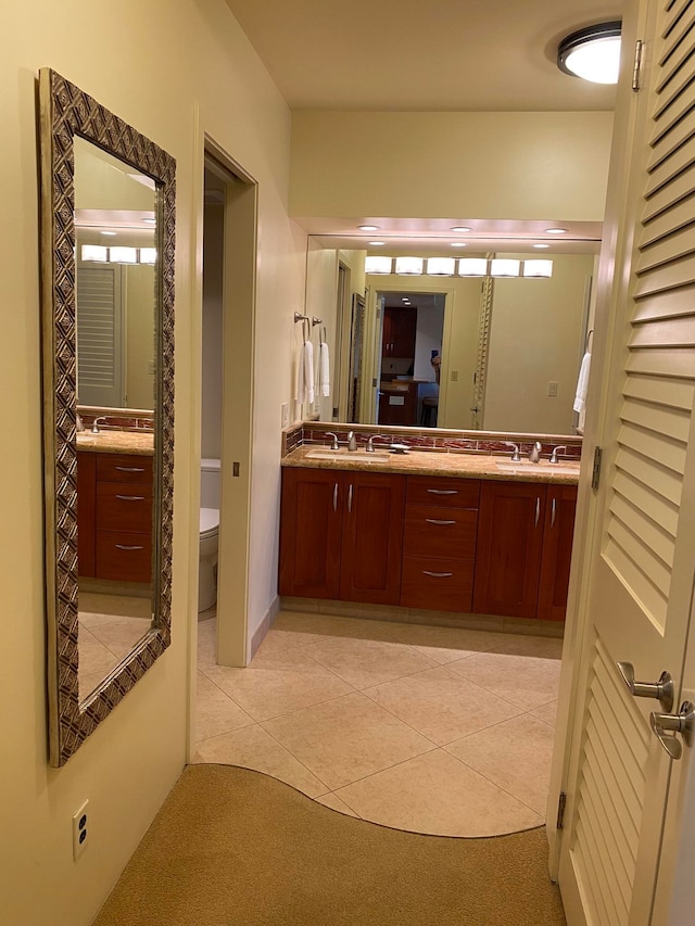 bathroom with vanity, toilet, and tile patterned floors