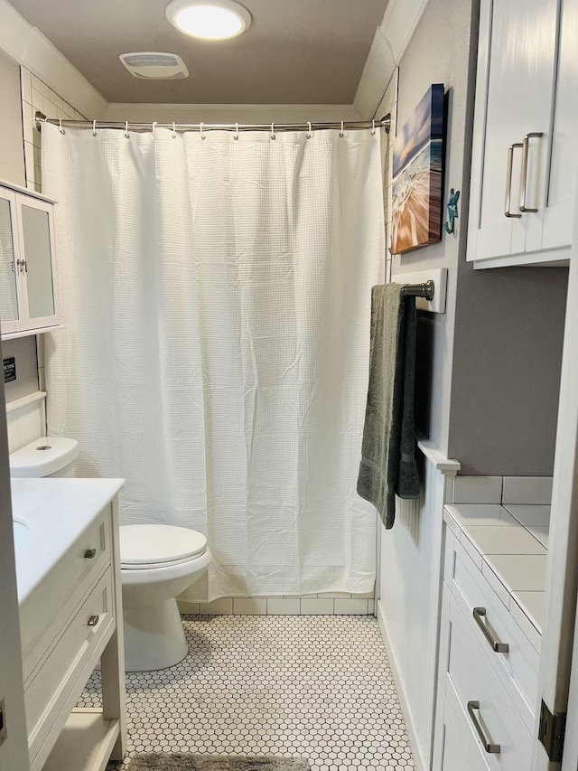 bathroom featuring toilet, vanity, and curtained shower