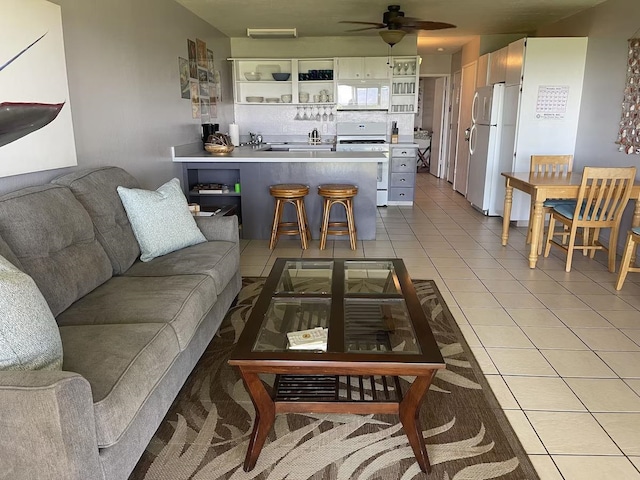 tiled living room featuring ceiling fan