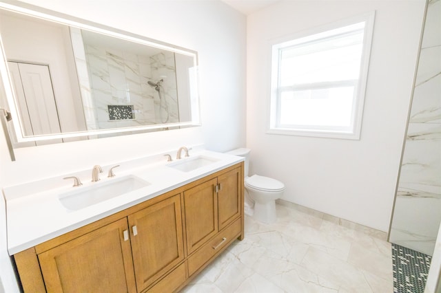 bathroom with vanity, a tile shower, and toilet