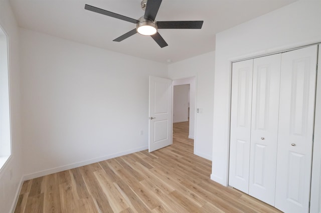 unfurnished bedroom featuring ceiling fan, a closet, and light hardwood / wood-style flooring