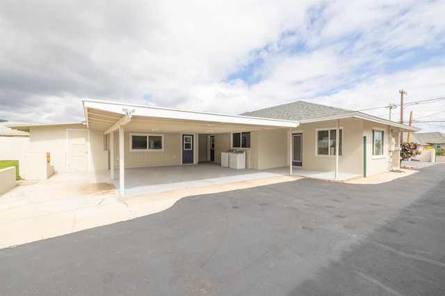 back of house featuring a carport