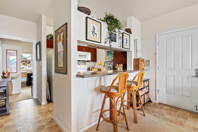 bar featuring light carpet, sink, and white appliances