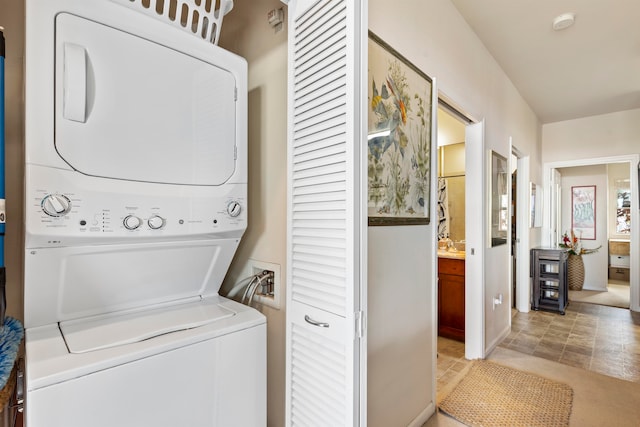 clothes washing area featuring stacked washer and clothes dryer