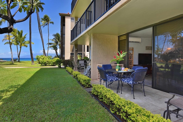 view of patio featuring a balcony, a water view, and an AC wall unit