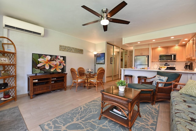 living room featuring ceiling fan, light wood-type flooring, and a wall unit AC