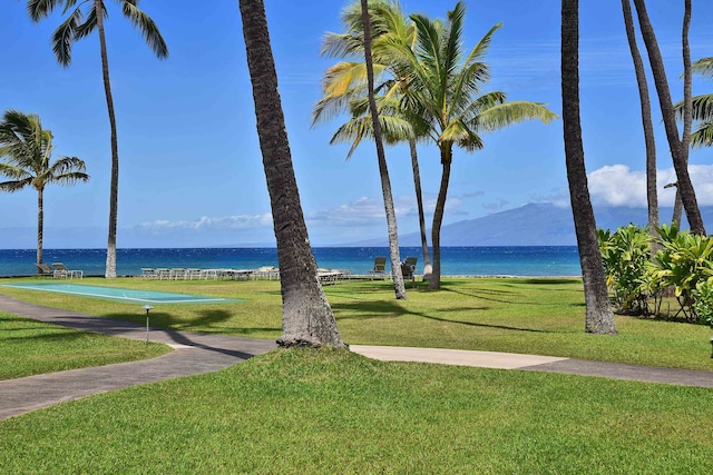 view of home's community with a water view and a yard