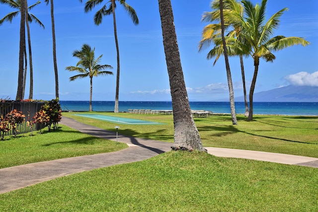 view of home's community with a lawn and a water view